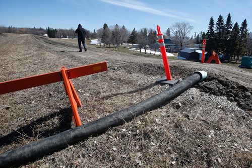 JOHN WOODS / WINNIPEG FREE PRESS
Jim Becker walks over a pump hose which crosses over the town dike in Emerson Sunday, April 14, 2019.

Reporter: Redekop