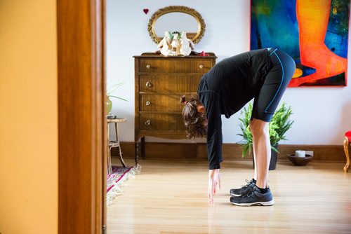 MIKAELA MACKENZIE/WINNIPEG FREE PRESS
Avid runner Sylvia Buchholz does a sun salutation before running to work in Winnipeg on Wednesday, April 17, 2019. 
Winnipeg Free Press 2019