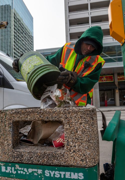 SASHA SEFTER / WINNIPEG FREE PRESS
General Maintenance worker James Turner of Downtown BIZ's Enviro empties his garbage pale into a trash can at the intersection of St Mary Avenue and Hargrave Street in downtown Winnipeg. See Declan Schroeder story.
190417 - Wednesday, April 17, 2019.