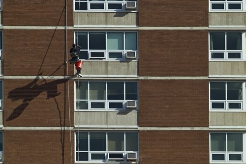 MIKE DEAL / WINNIPEG FREE PRESS
A window washer makes his way down the Lions Manor Thursday morning as temperatures are expected to reach 16C. 
190418 - Thursday, April 18, 2019