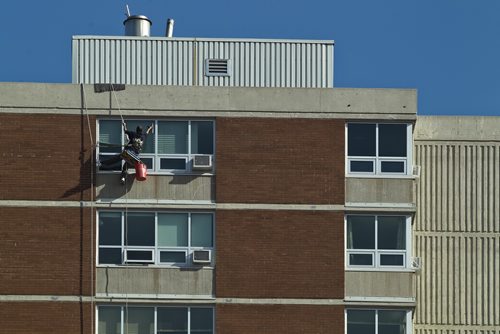 MIKE DEAL / WINNIPEG FREE PRESS
A window washer makes his way down the Lions Manor Thursday morning as temperatures are expected to reach 16C. 
190418 - Thursday, April 18, 2019