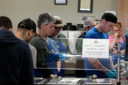 PHIL HOSSACK / WINNIPEG FREE PRESS - Workers bow their heads in prayer before serving turkey dinners to 300 plus 'patrons' at the LightHouse Mission on Main street for a traditional Good Friday holiday meal. See release.  - April 19, 2019.