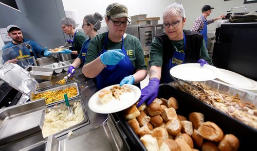 PHIL HOSSACK / WINNIPEG FREE PRESS - Volunteers Kelly Dueck (left) and Jenn Lynn Cook fill plates for 300 plus 'patrons' at the LightHouse Mission on Main street for a traditional Good Friday holiday meal. See release.  - April 19, 2019.