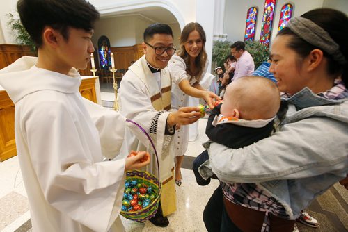 JOHN WOODS / WINNIPEG FREE PRESS
Fr Geoffrey Angeles, centre, and Benedicte Lemaitre hand out chocolate eggs to children during an Easter Mass at St Marys Cathedral in Winnipeg Easter Sunday, April 21, 2019.

Reporter: Rollason