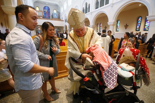 JOHN WOODS / WINNIPEG FREE PRESS
Archbishop of Winnipeg Richard Gagnon greets parishioners Archie and Mary Ballesteros and their newborn twins Anna and Hanna after an Easter Mass at St Marys Cathedral in Winnipeg Easter Sunday, April 21, 2019.

Reporter: Rollason