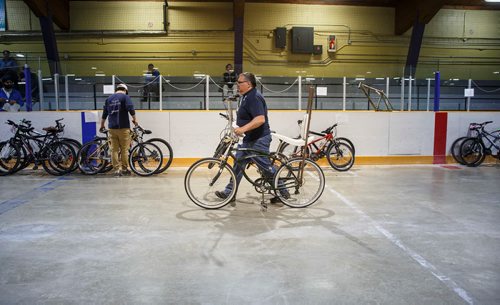 MIKE DEAL / WINNIPEG FREE PRESS
Volunteer Walter Potrebka takes a custom modified bike to its new owner during the bike auction.
About 650 bikes will go up for auction during the two-day annual City of Winnipeg bike sale at the Terry Sawchuck Arena, 901 Kimberly Ave. 
190427 - Saturday, April 27, 2019.