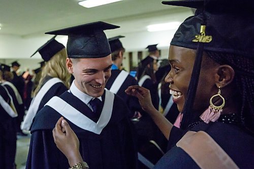 MIKE DEAL / WINNIPEG FREE PRESS
Fellow graduate Sincerely Sibanda helps Masimo Picaku during his graduation ceremony at the Portage Avenue Church Saturday afternoon.
Masimo Picaku is the first Albanian to graduate from CMU (with a business degree).
See John Longhurst story 
190427 - Saturday, April 27, 2019.