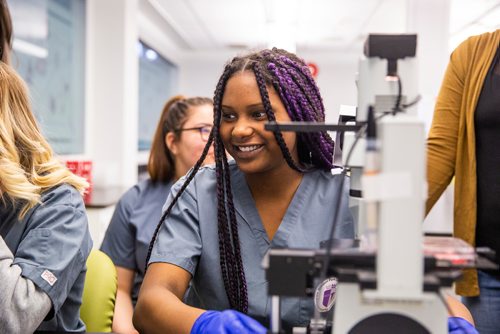 MIKAELA MACKENZIE/WINNIPEG FREE PRESS
Grade 10 students from the Medical Careers Exploration Program at Windsor Park Collegiate Iesha Carter laughs while examining cell samples dosed with vape pen vapour at the Youth BIOlab at the Albrechtsen Research Centre in Winnipeg on Thursday, May 2, 2019. 
Winnipeg Free Press 2019