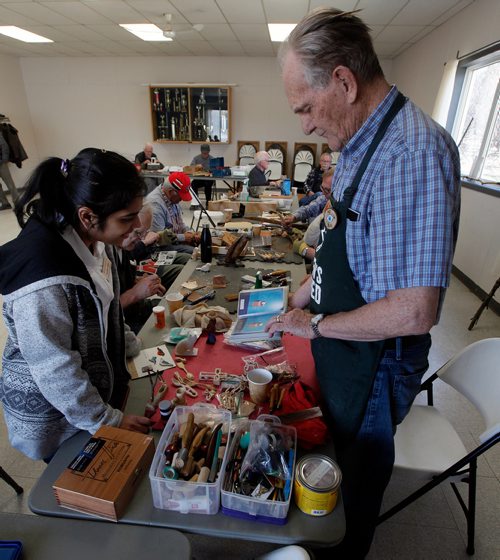 PHIL HOSSACK / WINNIPEG FREE PRESS - Twice a week retiree's gather at the Woodhaven CC where the "Mens Shack" hangs out over coffee carving and conversation.Bill Heron shows off an album of carving projects to avisiting student nurse.  - .....See Brenda Suderman's story. .  - May 8, 2019.