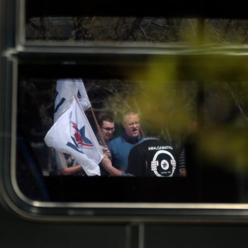 PHIL HOSSACK / WINNIPEG FREE PRESS - Seen through a transit bus window, ATU Local 1505 President speaks as Amalgamated Transit Union members wave flags and hand out leaflets outlining their protest action tomorrow at Edmonton St. and Graham ave Monday at noon hour. See Bill Redekop story.  - May13, 2019.