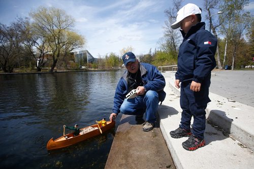 JOHN WOODS / WINNIPEG FREE PRESS
Wilson Yu looks on as Claude Dupuis of the Winnipeg Model Boat Club launches his model canoe powered by two wooden spoons and an electric motor at the Assiniboine Park duck pond in Winnipeg Sunday, May 19, 2019. 
Reporter: Intersection - Sanderson