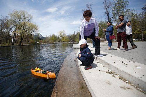JOHN WOODS / WINNIPEG FREE PRESS
Wilson Yu with his grandma Hui Yu and family look on as Claude Dupuis of the Winnipeg Model Boat Club operates his model canoe powered by two wooden spoons and an electric motor at the Assiniboine Park duck pond in Winnipeg Sunday, May 19, 2019. 
Reporter: Intersection - Sanderson
