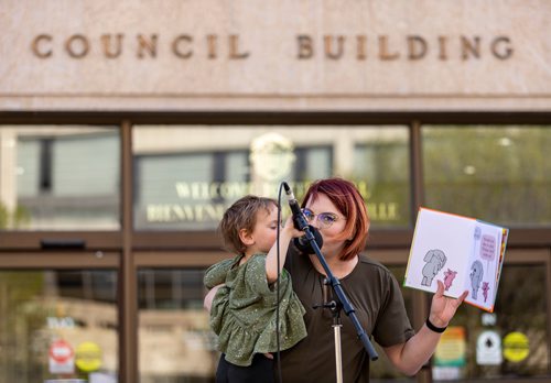 SASHA SEFTER / WINNIPEG FREE PRESS
Brianne Selman gets some help reading an excerpt from her daughters favourite book during a "read-out" event organized by the Millennium For All community group at Winnipeg City Hall.
190521 - Tuesday, May 21, 2019.