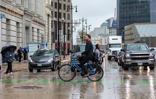 SASHA SEFTER / WINNIPEG FREE PRESS
Anders Swanson of the Winnipeg Trails Association rides his bike eastbound on McDermot Avenue across Main Street in the Exchange District.
190522 - Wednesday, May 22, 2019.