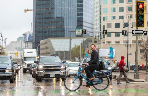 SASHA SEFTER / WINNIPEG FREE PRESS
Anders Swanson of the Winnipeg Trails Association rides his bike eastbound on McDermot Avenue across Main Street in the Exchange District.
190522 - Wednesday, May 22, 2019.