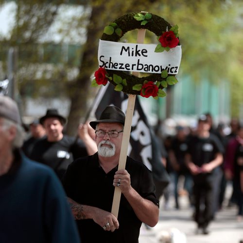 PHIL HOSSACK / WINNIPEG FREE PRESS - A  union member carries a wreath honouring Mike Schezerbanowicz, (father of three who died during the General Strike in 1919) down broadway ave Saturday during a parade to remember the 1919 General Strike. See Melissa Martin Story.  - May 25, 2019.