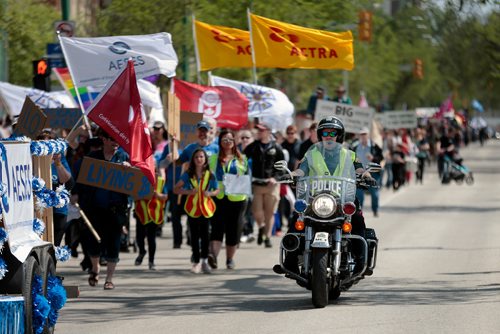 PHIL HOSSACK / WINNIPEG FREE PRESS - A city motorcycle officer accompanies union members down broadway ave Saturday during a parade to remember the 1919 General Strike. See Melissa Martin Story.  - May 25, 2019.
