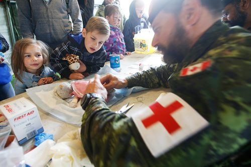 JOHN WOODS / WINNIPEG FREE PRESS
Elise, 4, left, and Aaron, 6, look on as 2nd Lt. Vince Saleni sews a toy at the Teddy Bear Picnic in Assiniboine Park, Winnipeg Sunday, May 26, 2019.

Reporter: ?
