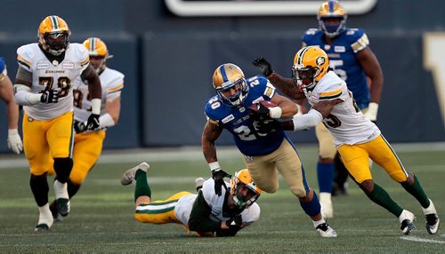 PHIL HOSSACK / WINNIPEG FREE PRESS -Winnipeg Blue Bomber #20 Brady Oliviera dodges a tackler from Edmonton Eskimo #20 Scott Hutter in Pre-Season action at Investor's Group Field Friday. Eskimo #29 Brian Walker closes in to make the tackle. See story. - May 31, 2019.