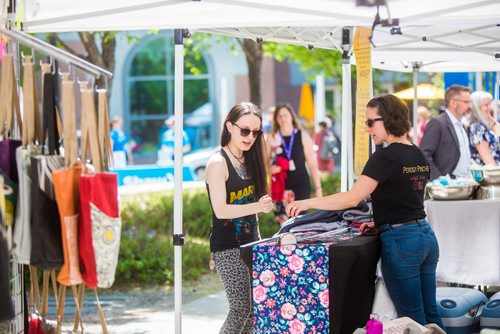 MIKAELA MACKENZIE / WINNIPEG FREE PRESS
Kristina Masseroni (left) checks out Amanda Desutter's wares at the first farmer's market of the year on Edmonton Street in downtown Winnipeg on Thursday, June 6, 2019. Standup.  
Winnipeg Free Press 2019.