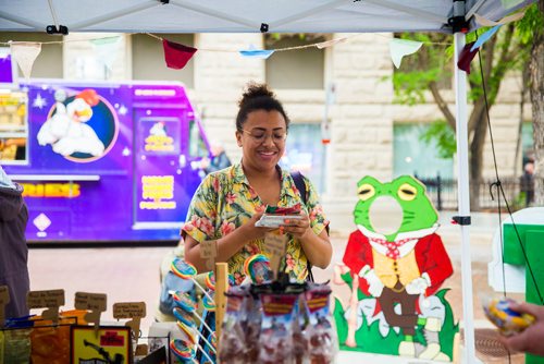 MIKAELA MACKENZIE / WINNIPEG FREE PRESS
Katelyn McIntyre looks at candy from the strike era at a Toad Hall food tent at the Rise Up 100: Songs for the Next Century Concert at Old Market Square in Winnipeg on Saturday, June 8, 2019. For Nadya story.  
Winnipeg Free Press 2019.