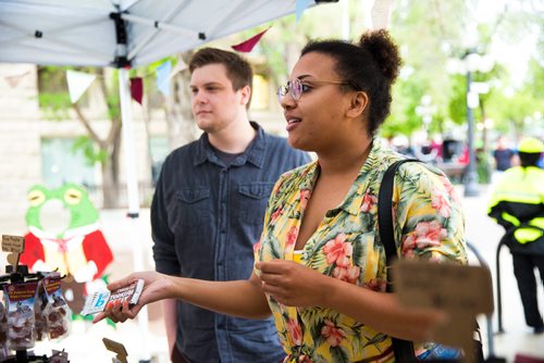MIKAELA MACKENZIE / WINNIPEG FREE PRESS
Katelyn McIntyre looks at candy from the strike era at a Toad Hall food tent at the Rise Up 100: Songs for the Next Century Concert at Old Market Square in Winnipeg on Saturday, June 8, 2019. For Nadya story.  
Winnipeg Free Press 2019.