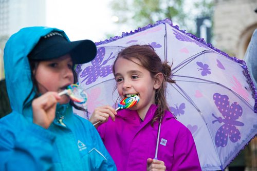 MIKAELA MACKENZIE / WINNIPEG FREE PRESS
Charlotte Hill, nine (right) and Natalie Phibbs, eight, eat lollipops (a candy that existed during the time of the strike) at the Rise Up 100: Songs for the Next Century Concert at Old Market Square in Winnipeg on Saturday, June 8, 2019. For Nadya story.  
Winnipeg Free Press 2019.