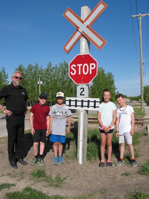 Canstar Community News June 6, 2019 - (From left) La Salle School principal Robert Bouchard and students Griffen, Cole, Hannah and Grant stand at the CP Rail crossing on Second Avenue in La Salle. The school's administrators, teachers and parents are concerned about the safety of students who cross the uncontrolled rail line when they walk and cycle to and from school, and are asking for crossing arms and lights to be installed. (ANDREA GEARY/CANSTAR COMMUNITY NEWS)