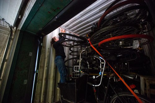 MIKAELA MACKENZIE / WINNIPEG FREE PRESS
Leigh Anne Parry, co-founder of the Plain Bicycle Project, undoes the straps holding old Dutch bikes in a shipping container before unloading them in Winnipeg on Tuesday, June 11, 2019. For Alex Paul story.  
Winnipeg Free Press 2019.