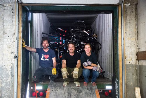 MIKAELA MACKENZIE / WINNIPEG FREE PRESS
Anders Swanson (left), Ian Frank, and Leigh Anne Parry, co-founders of the Plain Bicycle Project, pose for a portrait while unloading old Dutch bikes in a shipping container in Winnipeg on Tuesday, June 11, 2019. For Alex Paul story.  
Winnipeg Free Press 2019.