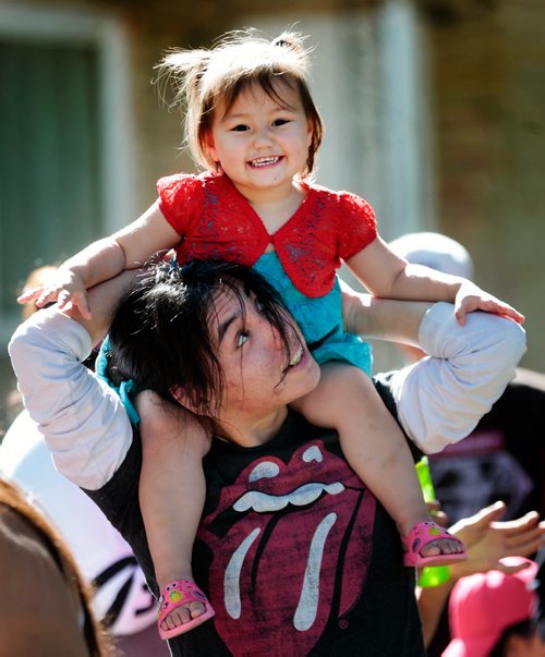 PHIL HOSSACK / WINNIPEG FREE PRESS - Soul Swampy peers up at his two year old daughter Scarlett Wednesday afternoon as the pair waited in a long line for a hot dog at an inner city block party along Aberdeen between Powers and Salter. See release. - June 12, 2019.
