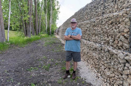 SASHA SEFTER / WINNIPEG FREE PRESS
Perry Kowal's house borders onto a new retaining wall which developers have installed in order to massively expand a trailer park. Kowal stands 5'8'' and believes the retaining Wass is at least 10 feet high.
190613 - Thursday, June 13, 2019.