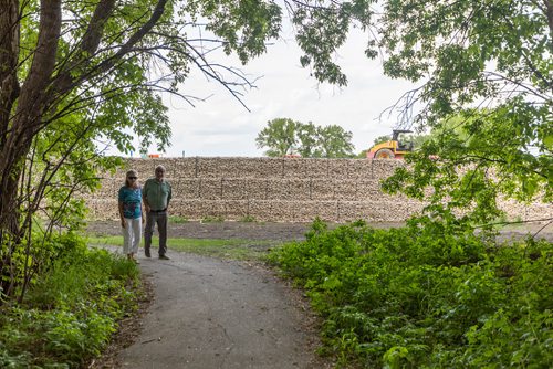 SASHA SEFTER / WINNIPEG FREE PRESS
Passers by gawk at a new nearly 10 foot high retaining wall which developers have installed in order to massively expand a trailer park near Rivergrove Park.
190613 - Thursday, June 13, 2019.