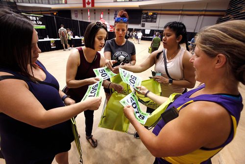 PHIL HOSSACK / WINNIPEG FREE PRESS - Left to right pregnant marathoners; Ashly Reyes, Maddie Fontaine, Breanne Peters, Marie Lospe and team captain Reesa Simmonds pose sort through their numbers after picking up their race packages for Sunday's Marathon Friday. The five expectant mothers are running a relay race. See story. - June 14 2019.