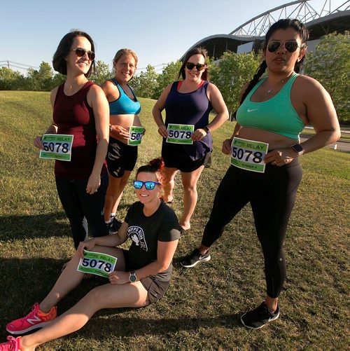 PHIL HOSSACK / WINNIPEG FREE PRESS - pregnant marathoners; Sitting, Breanne Peters, standing  Left to right  Maddie Fontaine, Reesa Simmonds, Ashly Reyes, and Marie Lospe  pose with their numbers for Sunday's Marathon. The five expectant mothers are running a relay race. See story. - June 14 2019.