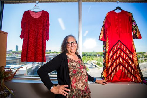 MIKAELA MACKENZIE / WINNIPEG FREE PRESS
Darlene Douglas, New Directions director of culture, education and training, with two of the 350 red dresses that theyre hanging Thursday in every window of their building at 717 Portage in Winnipeg on Wednesday, June 19, 2019. For Carol Sanders story.
Winnipeg Free Press 2019.