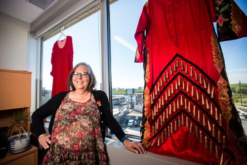 MIKAELA MACKENZIE / WINNIPEG FREE PRESS
Darlene Douglas, New Directions director of culture, education and training, with two of the 350 red dresses that theyre hanging Thursday in every window of their building at 717 Portage in Winnipeg on Wednesday, June 19, 2019. For Carol Sanders story.
Winnipeg Free Press 2019.