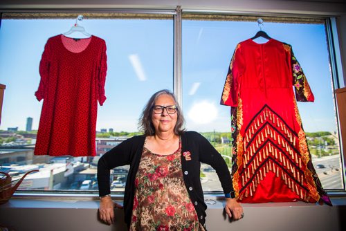 MIKAELA MACKENZIE / WINNIPEG FREE PRESS
Darlene Douglas, New Directions director of culture, education and training, with two of the 350 red dresses that theyre hanging Thursday in every window of their building at 717 Portage in Winnipeg on Wednesday, June 19, 2019. For Carol Sanders story.
Winnipeg Free Press 2019.