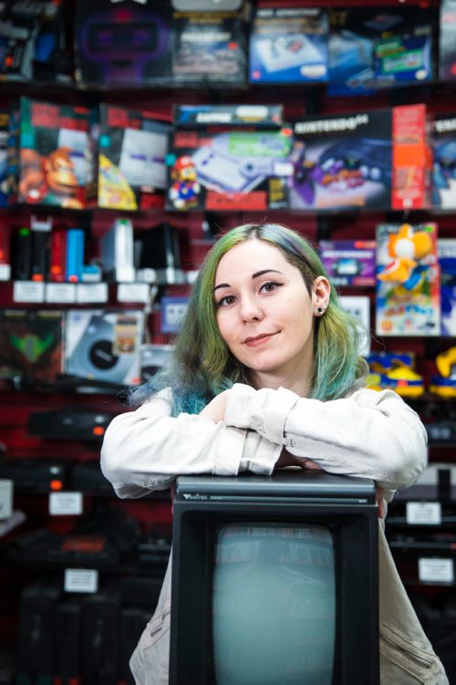 MIKAELA MACKENZIE / WINNIPEG FREE PRESS
Cobra Collectibles manager Kailyn Gregorash poses for a photo with a Vectrex in front of vintage video game consoles in the store in Winnipeg on Thursday, June 20, 2019. For Declan story.
Winnipeg Free Press 2019.