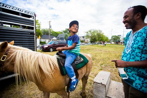MIKAELA MACKENZIE / WINNIPEG FREE PRESS
Yussuf Ahmed, four, smiles back to his dad, Abdikheir Ahmed, on a pony at Aboriginal Day festivities at the Freighthouse Community Centre in Winnipeg on Friday, June 21, 2019. 
Winnipeg Free Press 2019.