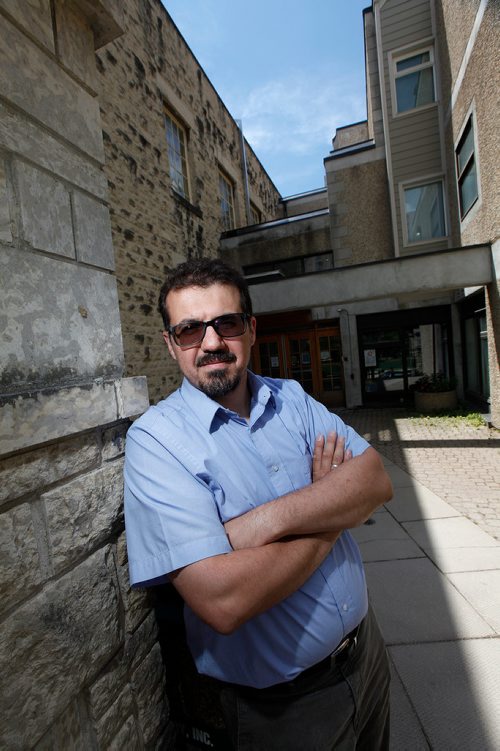 PHIL HOSSACK / WINNIPEG FREE PRESS -  Idris Albakri poses in front of the common area between Knox United Church and The building purchased by the Manitoba Muslim Association. See Brenda Suderman story.- June 25, 2019.
