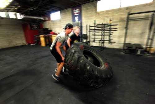 PHIL HOSSACK / WINNIPEG FREE PRESS - Cole Younger (grey shirt) and Easton Lewicki (black shirt) flip a giant tire around the Cross Fit 204 Gym Wednesday evening. The 15 yr old teenagers are part of a summer fitness program run by owner Ryan Stewart. See Sabrina Carnevale story.  - July 3, 2019.