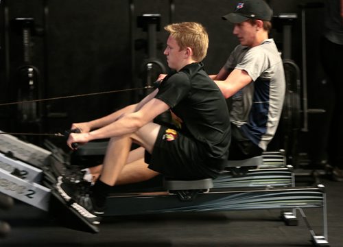 PHIL HOSSACK / WINNIPEG FREE PRESS - Cole Younger (grey shirt) and Easton Lewicki (black shirt) row as part of their routine at the Cross Fit 204 Gym Wednesday evening. The 15 yr old teenagers are part of a summer fitness program. See Sabrina Carnevale story.  - July 3, 2019.