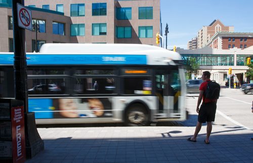 MIKE DEAL / WINNIPEG FREE PRESS
A bus zips past people waiting at a bus stop in Winnipeg's downtown Thursday afternoon.
190704 - Thursday, July 04, 2019.