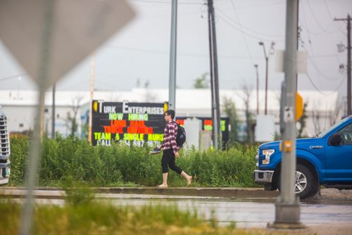 MIKAELA MACKENZIE / WINNIPEG FREE PRESS
A pedestrian takes off their wet shoes to walk on Inkster at Route 90 in Winnipeg on Wednesday, July 10, 2019. Standup.
Winnipeg Free Press 2019.