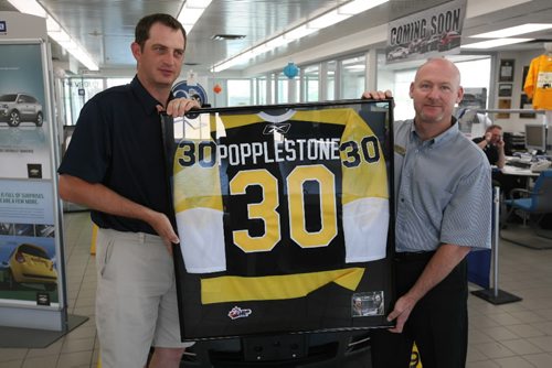 Brandon Sun Bruce Leubke holds a personalized Wheat Kings jersey with Ron Popplestone, Monday afternoon at Murray Chev Olds. Popplestone was being honoured for ten years of colour commentary of Wheat Kings hockey games. FOR GRANT (Colin Corneau/Brandon Sun)