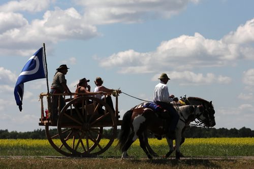Brandon Sun 06072009 One of two solid oak Red River carts, driven by members of the Red River Métis Heritage Group and accompanied by other members on horseback, makes it's way towards Harmsworth, Man. on the first day of their journey to Fort Ellice.  (Tim Smith/Brandon Sun)