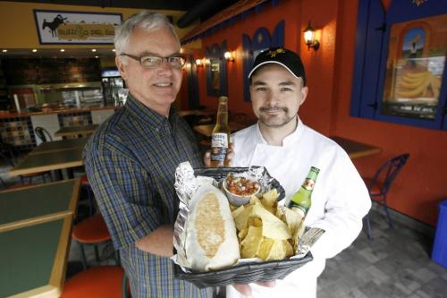 MIKE.DEAL@FREEPRESS.MB.CA 090716 Burrito Del Rio owner Duncan Grant (left) with a pulled pork burrito and chips and manager Ray Ferchuk with a couple of mexican beers. WINNIPEG FREE PRESS