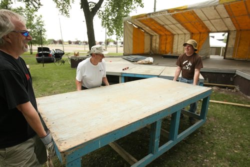 Brandon Sun John Scott (left) Richard Harby and Dave McLean help set up the main stage Thursday afternoon for this weekend's Brandon Folk, Music and Art Festival at the Keystone Centre grounds. The gate opens at 6:30 p.m. today for the festival's 25th anniversary. (Colin Corneau/Brandon Sun)