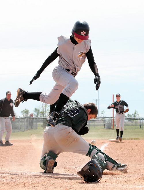 Brandon Sun 03082009 Colin Bouchard #13 of Bonivital leaps over catcher Derek Nevins #49 of the Brandon Knights to score the winning run in their semifinal match-up at the Bantam AAA Provincial Championships at Simplot Millennium Park in Brandon on Monday. Bonivital went into the bottom of the seventh inning behind 3-1 but rallied to defeat Brandon with a final score of 4-3. (Tim Smith/Brandon Sun)